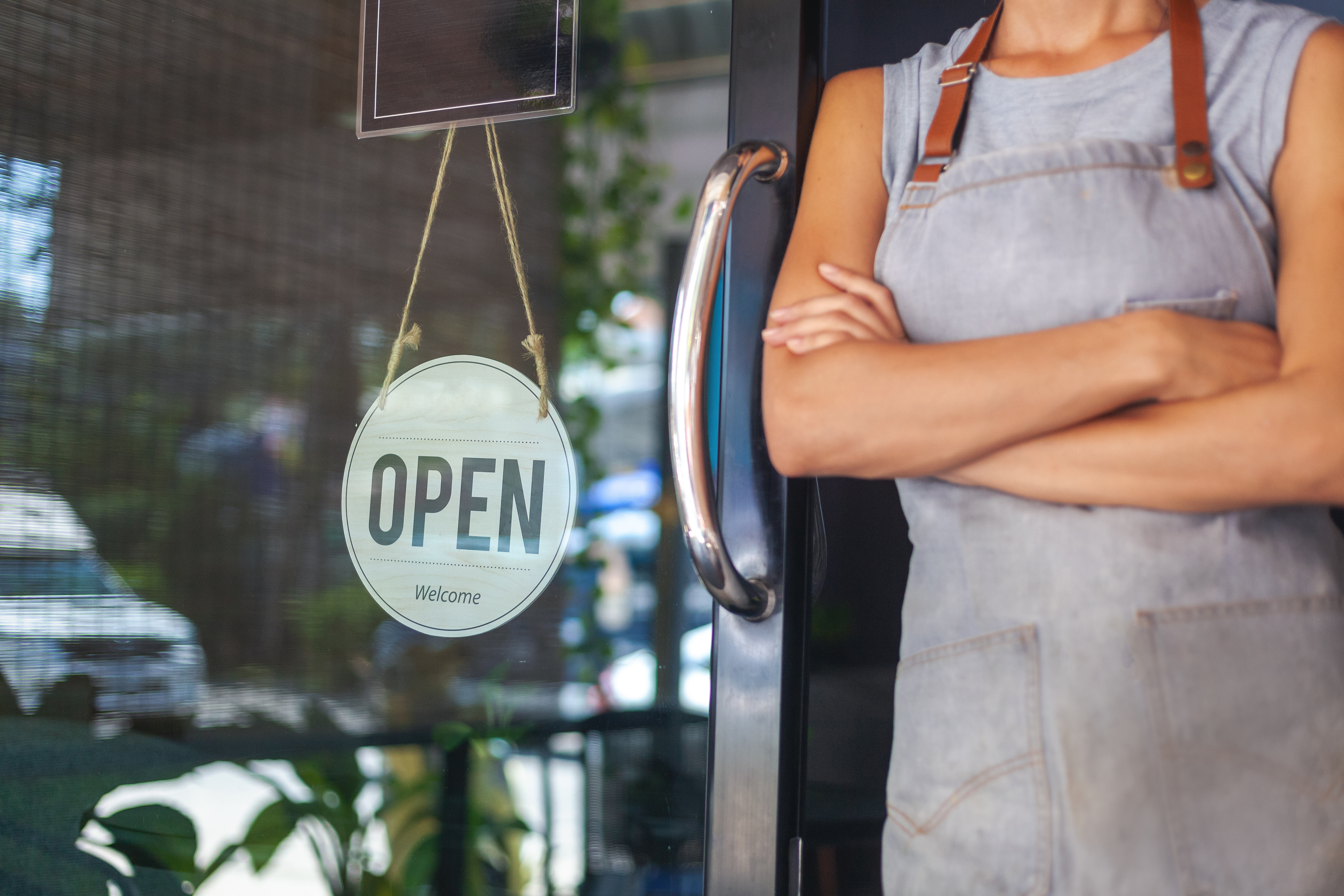 Small business owner standing at open door
