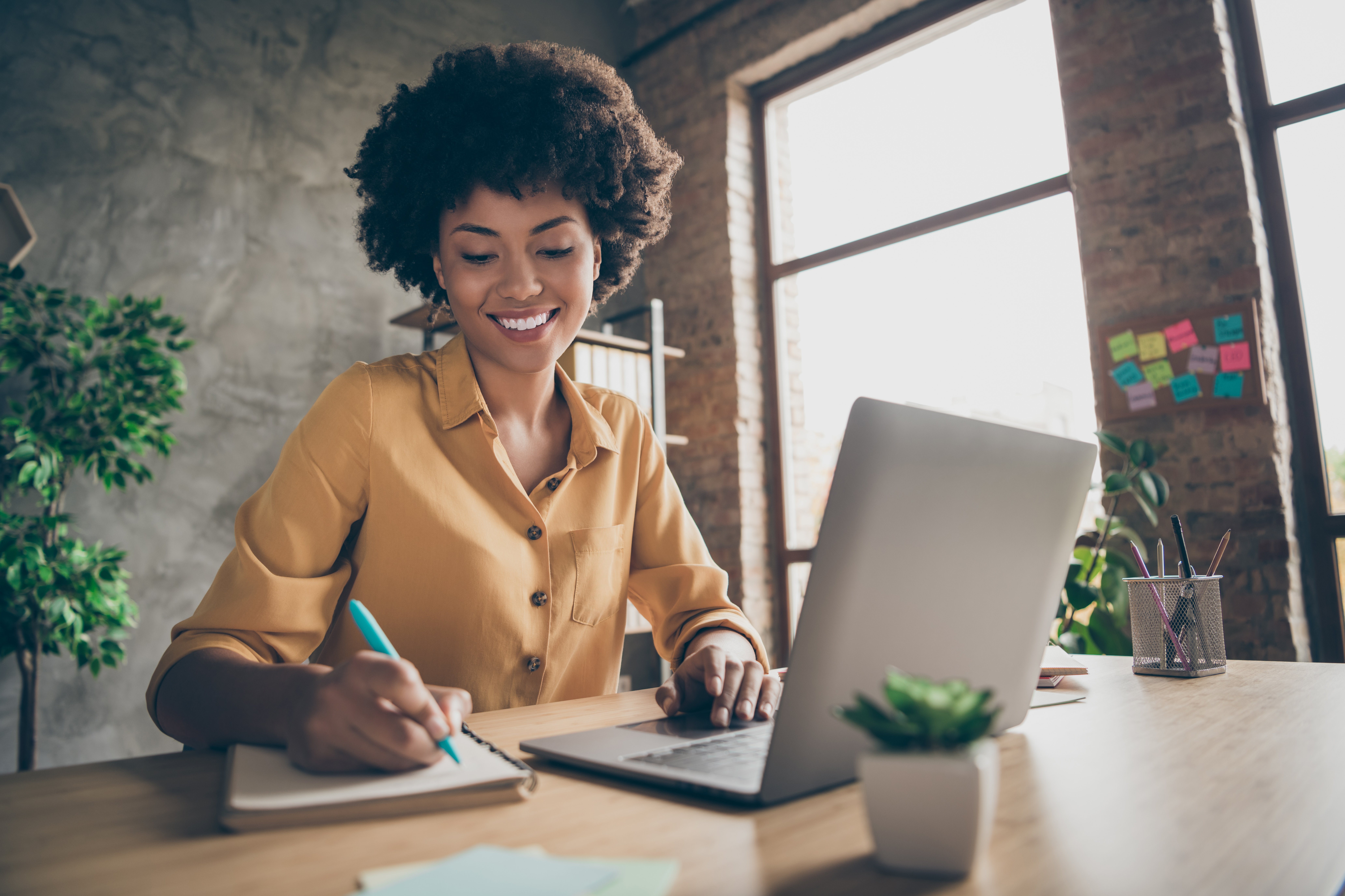 Virtual assistant working at laptop and taking notes